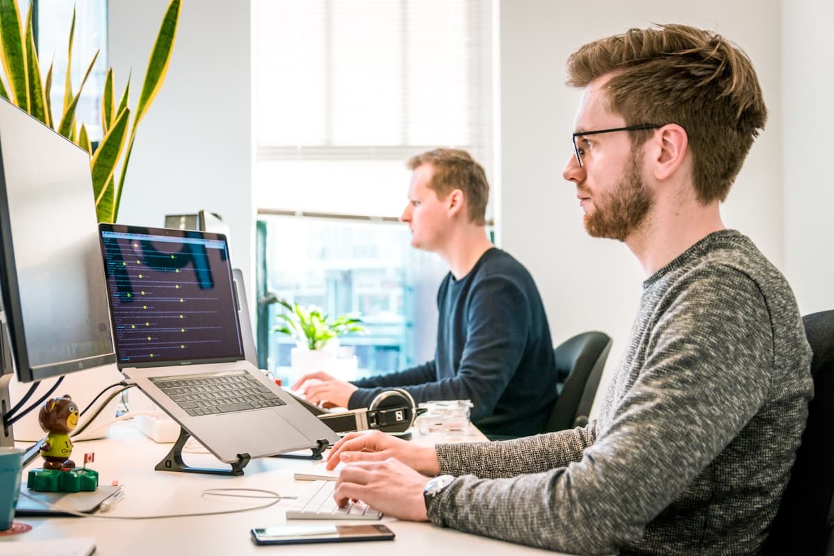 Developers collaborating at a desk with computers