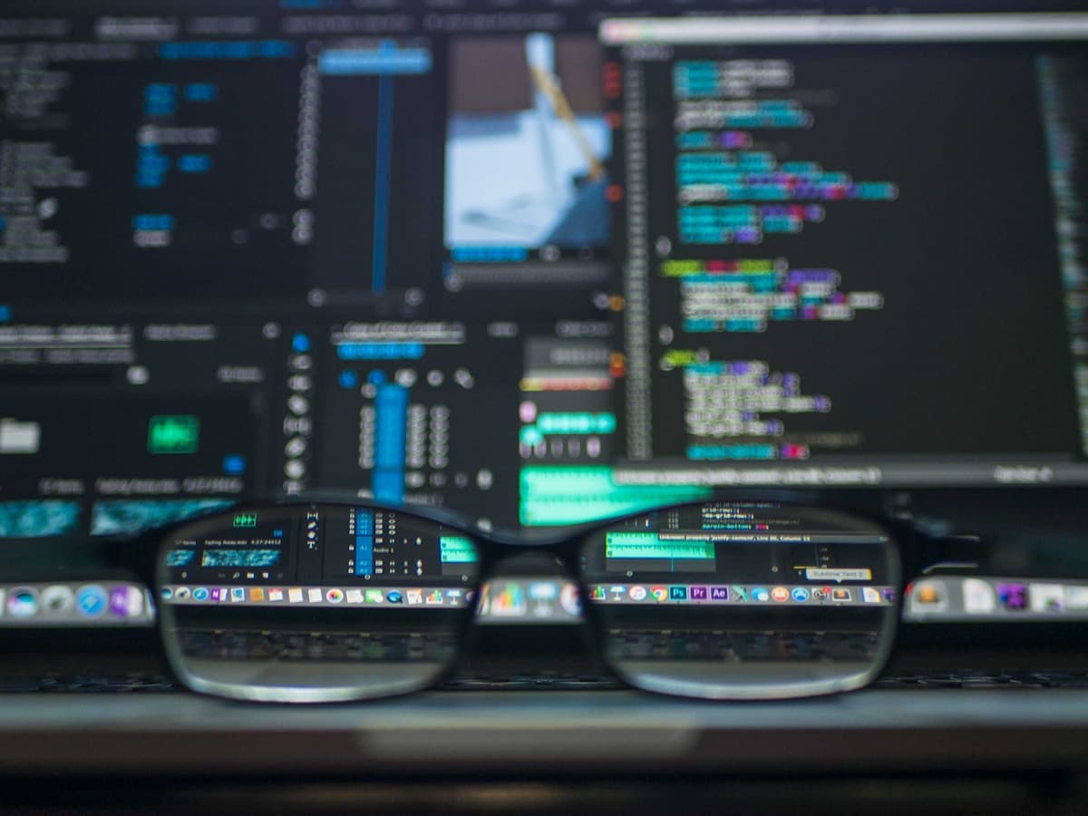 Developer typing on keyboard with multiple monitors